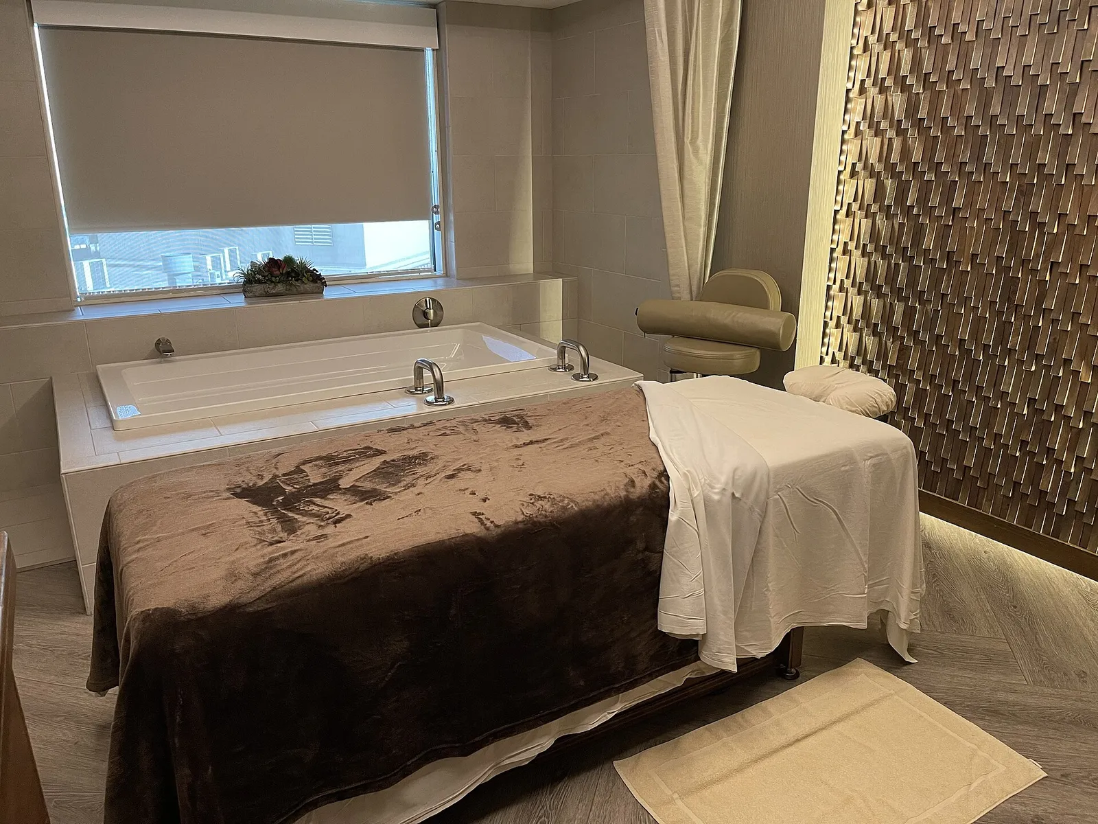 Spa treatment room with massage bed and bathtub
