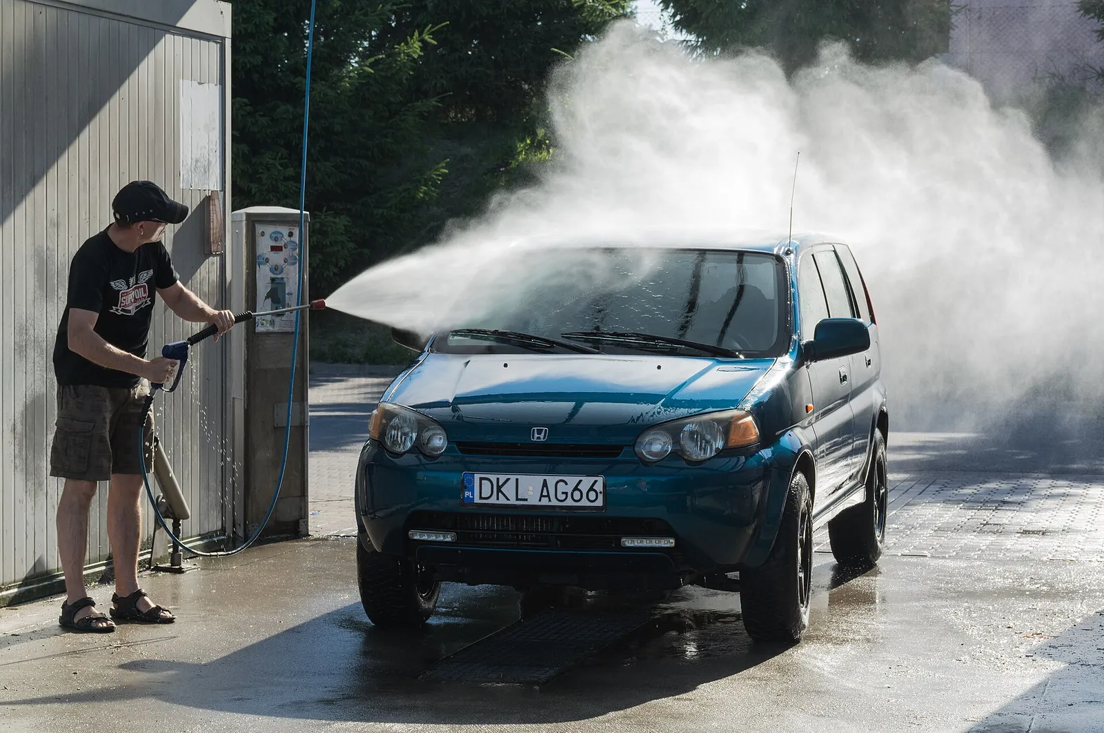 Car being pressure-washed at a self-service car wash