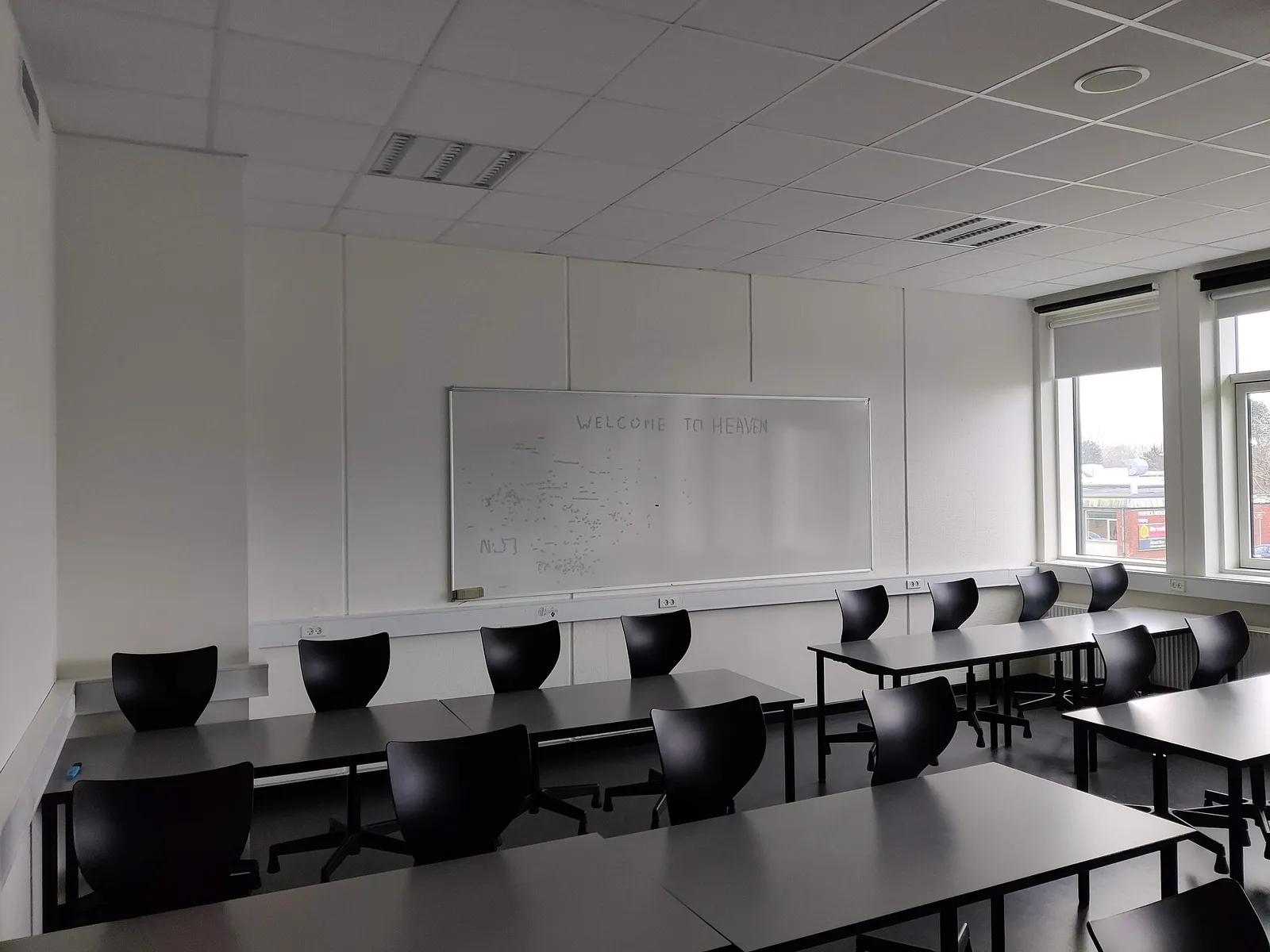 Empty classroom with desks, chairs and a whiteboard