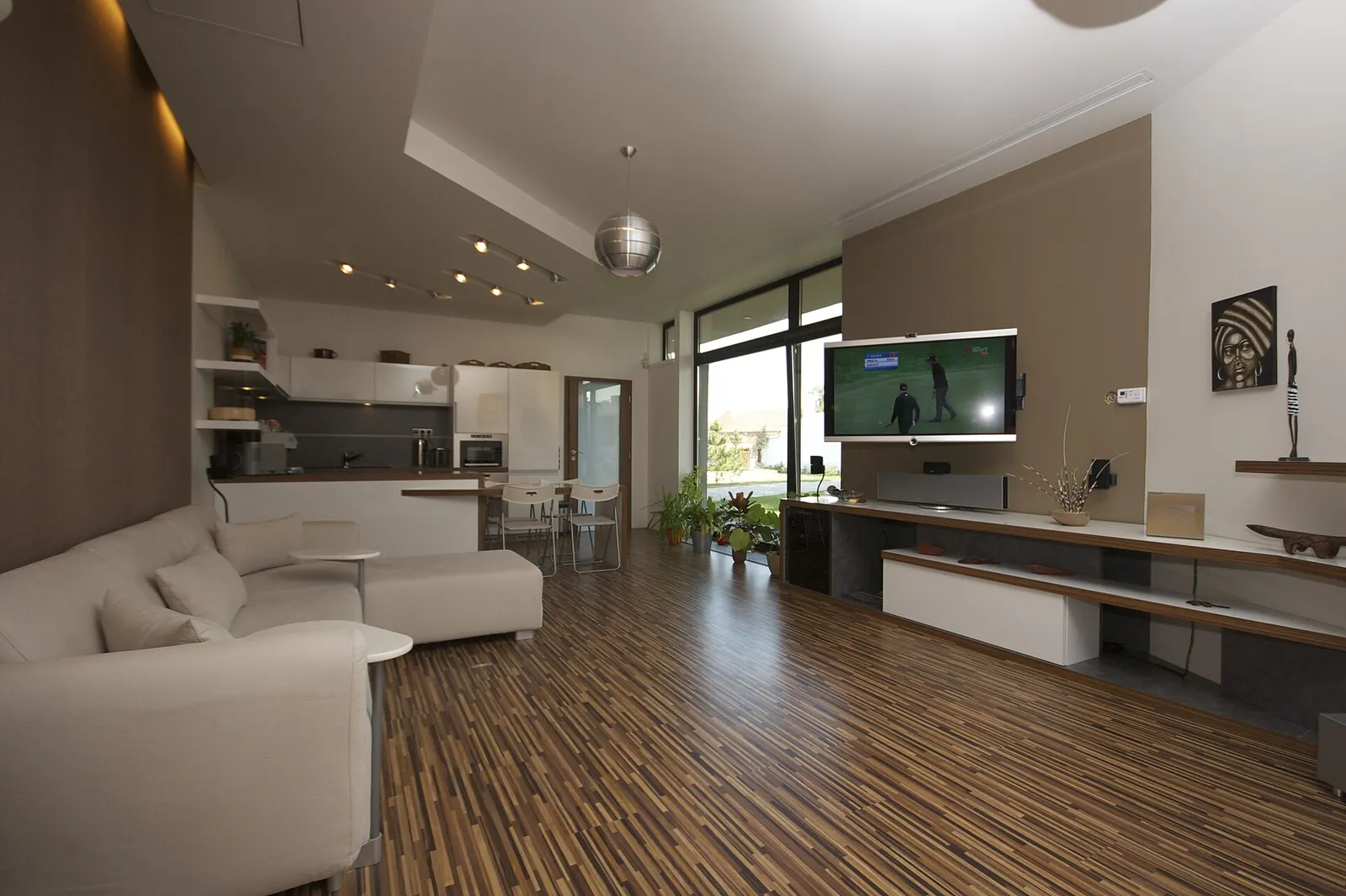 Modern open-plan living room with white sofa and kitchen