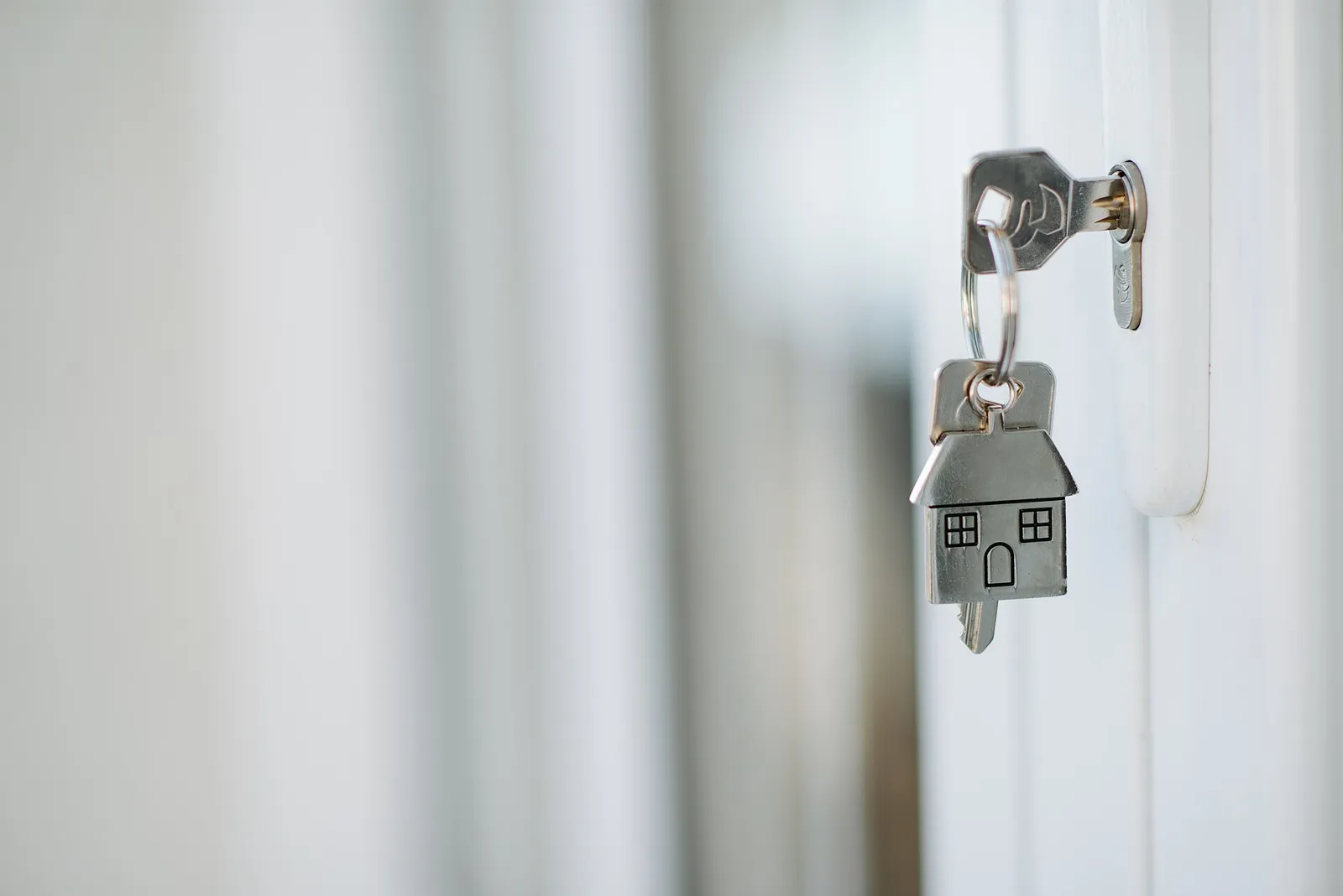 Door key with a house-shaped keychain in a lock