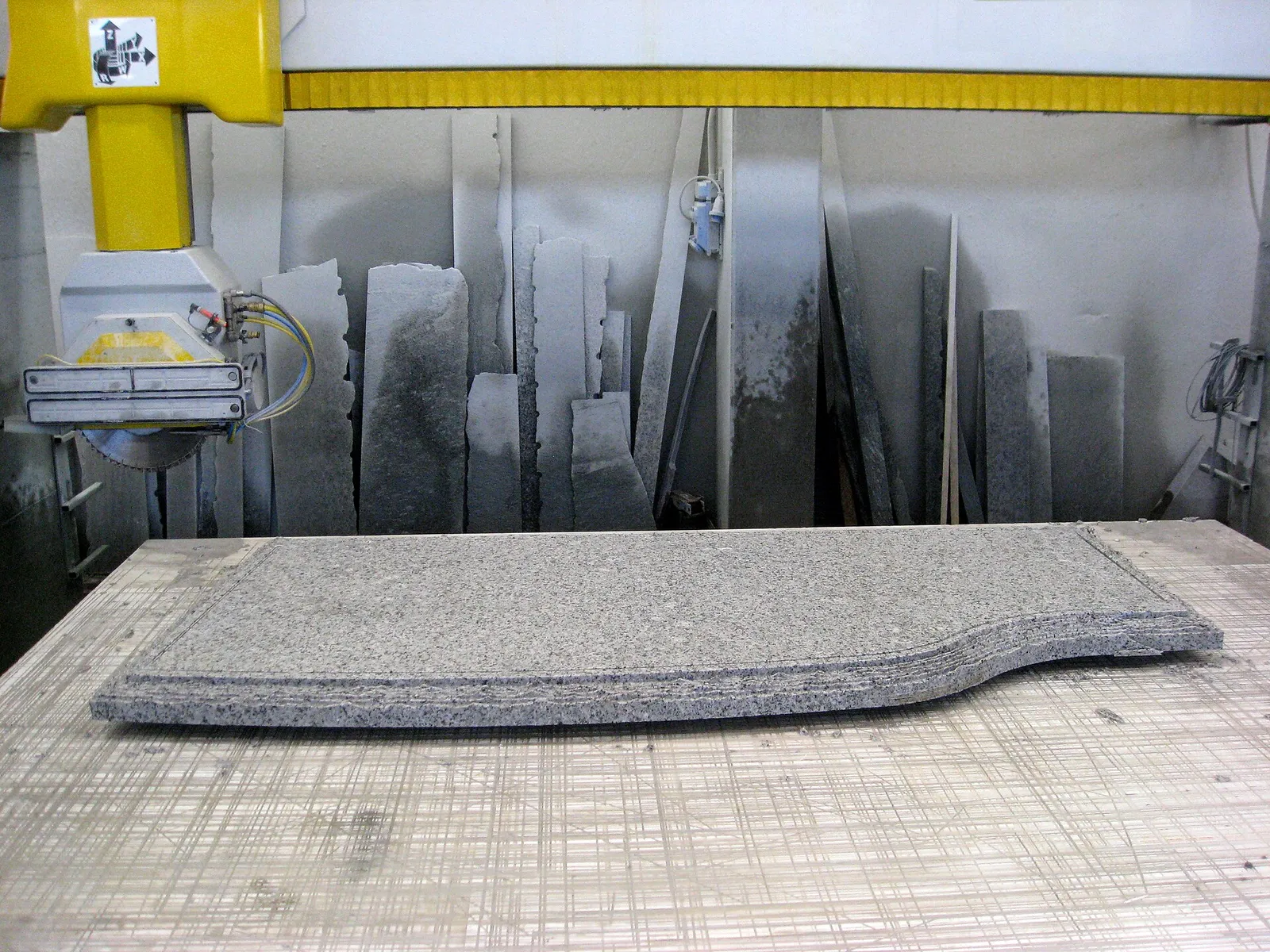 Bridge saw shaping a stone slab in a stone workshop