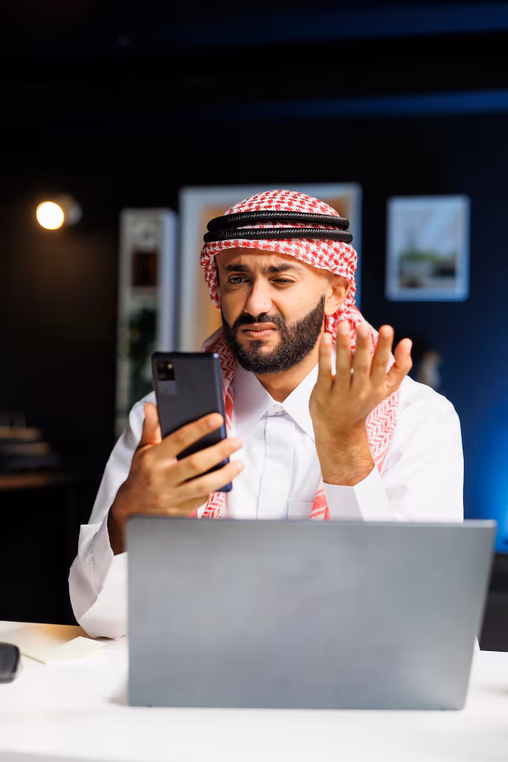 Saudi entrepreneur using a mobile app on his smartphone