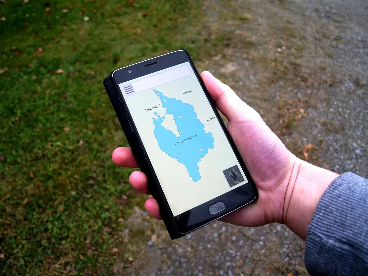 A hand holding a smartphone with a map app open